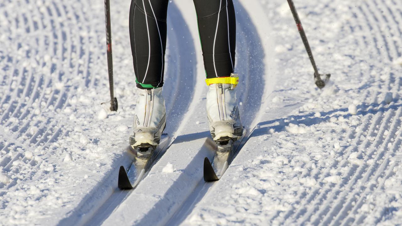 En person som åker skidor i preparerat spår.