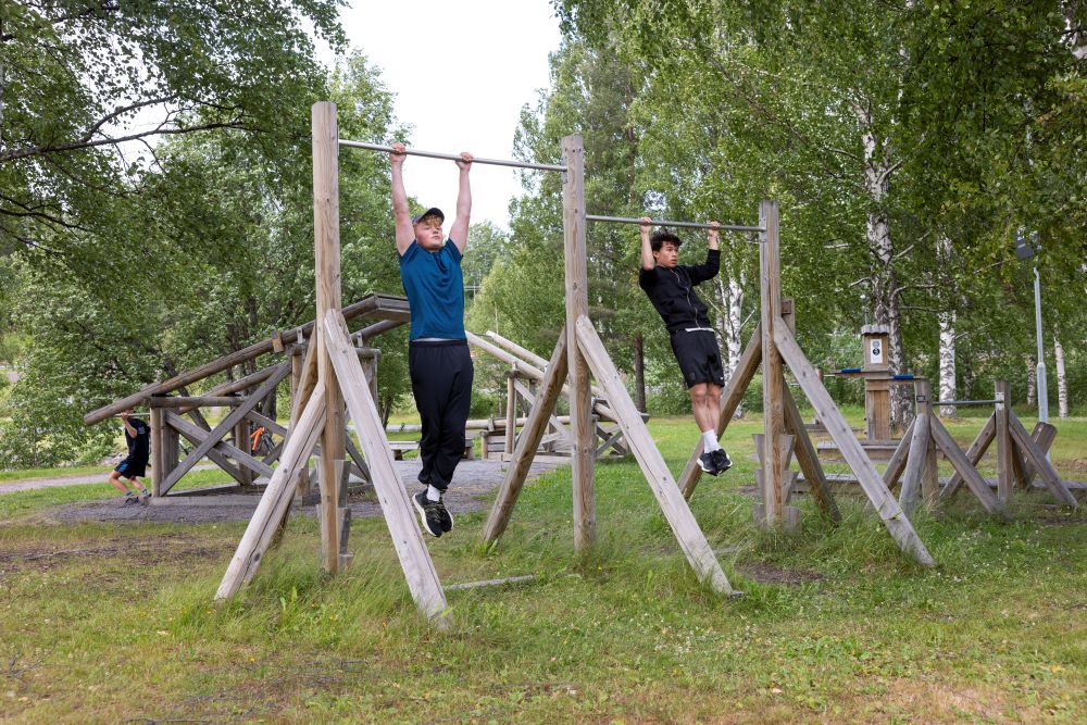 Tre unga killar testar utegymmet.