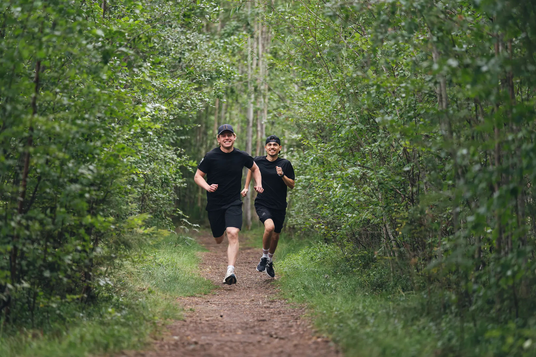 Närbild på kängorna på en person som vandrar efter en led med skog omkring.