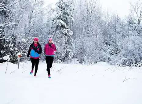 Två personer joggar på en stig