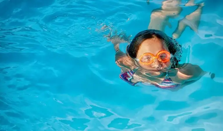 Barn som simmar i en pool