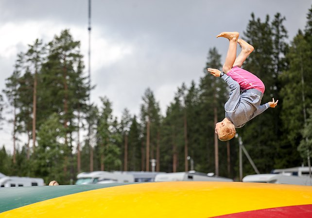 En pojke gör volter på en av de stora hoppkuddarna i campingens lekpark.