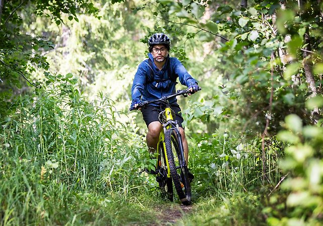 Man som cyklar på en stig