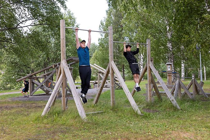två killar tränar i utegymmet