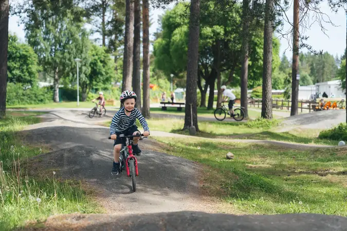 Liten kille som cyklar på en BMX-bana