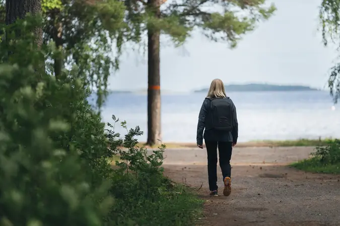 Kvinna som är ute och promenerar vid vattnet