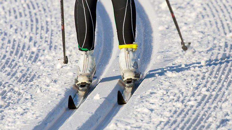 En person som åker skidor i preparerat spår.