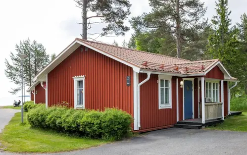 Uteplats på stuga med utsikt över stugområdet och badet.